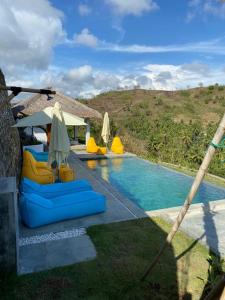 basen z leżakami i parasolami obok w obiekcie Lombok Khophilauvillas w Kuta Lombok