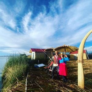 Ein Mann und eine Frau stehen unter einem Schirm in der Unterkunft Uros Titicaca Khantaniwa Lodge in Puno