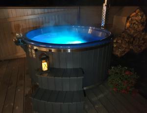 un jacuzzi en el patio trasero por la noche en KK Apartment, en Ventspils