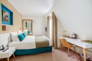 a hotel room with a bed and a desk at Queens Boutique Hotel in Paris