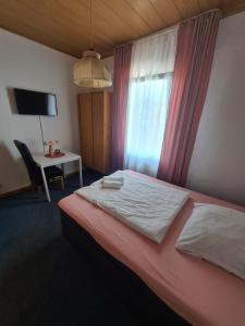 1 dormitorio con cama, escritorio y ventana en Hotel Dalmacija, en Mayen