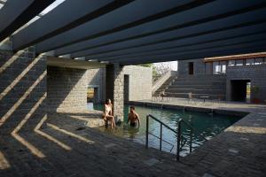 zwei Personen sitzen in einem Pool voller Wasser in der Unterkunft Viveda Wellness Resort in Nashik