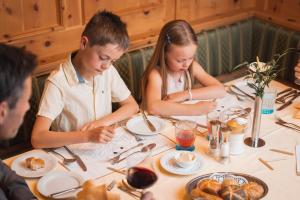 Un groupe de personnes assises à une table et mangeant de la nourriture dans l'établissement Alpenpark Resort Superior, à Seefeld in Tirol