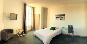 - une chambre avec un lit, un bureau et une chaise dans l'établissement Colette Hôtel, à Niort