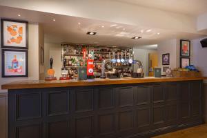 a bar with a large wooden counter in a room at The White Horse Hotel, Romsey, Hampshire in Romsey