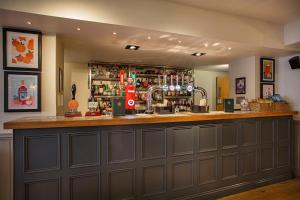 a bar in a pub with a brown wall at The White Horse Hotel, Romsey, Hampshire in Romsey