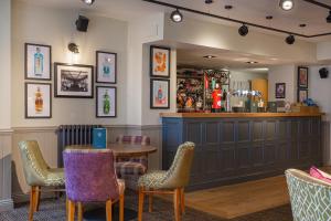 a restaurant with a table and chairs and a bar at The White Horse Hotel, Romsey, Hampshire in Romsey