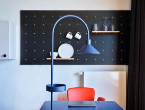 a table with a chair and a lamp in a room at STAYERY Cologne Ehrenfeld in Cologne