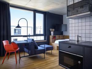 a room with a kitchen and a bedroom with a bed at STAYERY Cologne Ehrenfeld in Cologne