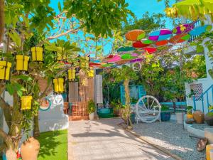 um jardim com papagaios coloridos pendurados nas árvores em MAY Bungalow em Mui Ne