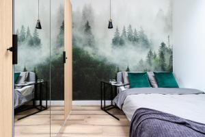 um quarto com um mural de floresta na parede em KOBIELA Luxury Aparthotel KTW City Center em Katowice