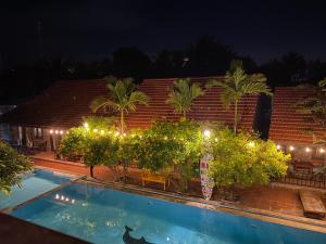 uma piscina em frente a um edifício à noite em MAY Bungalow em Mui Ne