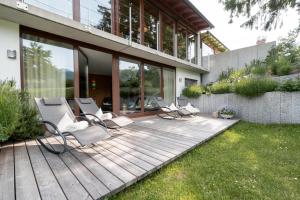 een houten terras met stoelen en een huis bij Schlegelhof in Kirchzarten