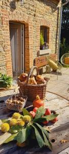 - une corbeille de pain et des paniers de fruits sur la terrasse dans l'établissement La Faironnière, à Hamoir