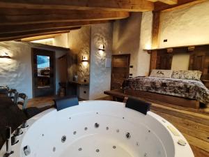 a bedroom with a bed and a table in a room at AL BAIT DA LUCIA Bormio in Bormio