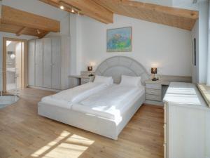 - une chambre blanche avec un grand lit et un bureau dans l'établissement Center Rooms & Apartments, à Mayrhofen