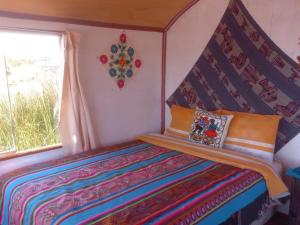 ein kleines Schlafzimmer mit einem Bett mit Baldachin in der Unterkunft Uros Titicaca Khantaniwa Lodge in Puno