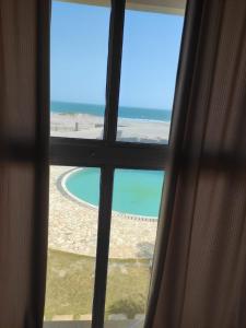 Vilas Na Praia Residence Condomínio في كانووا كويبرادا: منظر المحيط من النافذة