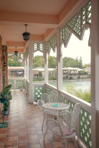 a screened porch with a table and chairs at Hotel Paradise Road in Kutaisi