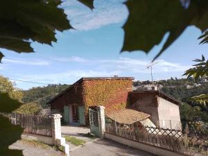 ein Haus auf einem Hügel mit einem Zaun in der Unterkunft Le Chalet du Parc in Annonay