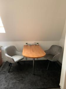 een tafel en 2 stoelen in een kamer bij Ferienwohnung Lüttje Hörn in Emden