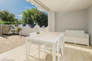 una mesa blanca y sillas en la sala de estar. en Villetta a Mare, en Olbia