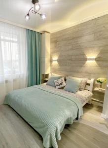 a bedroom with a large bed with a blue blanket at Tiffany Apartment in Irpin'