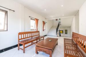 a living room with two benches and a table at Ganandra Stay Denpasar in Denpasar