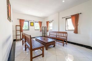 a living room with two benches and a table at Ganandra Stay Denpasar in Denpasar