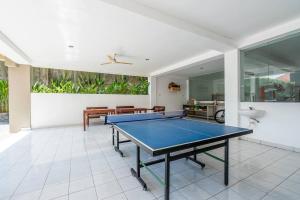 a dining room with a ping pong table in it at Ganandra Stay Denpasar in Denpasar