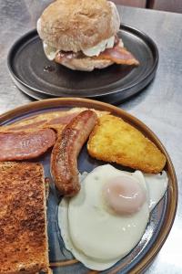 - une assiette de petit-déjeuner avec un sandwich et une saucisse dans l'établissement Lodge Dinorwig, à Llanberis