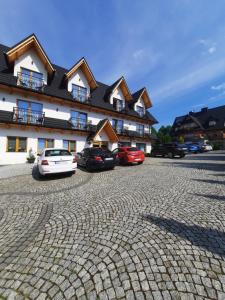 a group of cars parked in front of a building at Willa Grand Krzesanica in Kościelisko