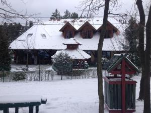 ein schneebedecktes Haus mit einem Vogelfutter davor in der Unterkunft Napkorong Fogadó és Vendégház in Piliscsaba