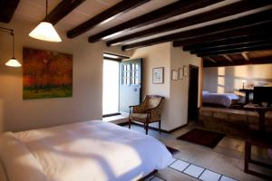 - une chambre avec un grand lit blanc et un bureau dans l'établissement Lazareto Hotel, à Monemvasia