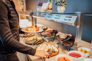 une femme debout devant un buffet avec de la nourriture dans l'établissement Hotel Crni Vrh, à Divčibare