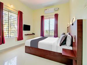 een slaapkamer met een groot bed met rode gordijnen bij BLUEWAY RESIDENCY BUSINESS BOUTIQUE HOTEL in Trivandrum