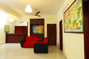 een woonkamer met een rode stoel en een bank bij BLUEWAY RESIDENCY BUSINESS BOUTIQUE HOTEL in Trivandrum