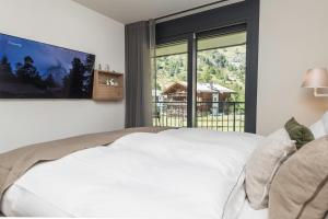 sypialnia z dużym białym łóżkiem i dużym oknem w obiekcie Apartment in Chalet Pizzo Fiamma w mieście Zermatt