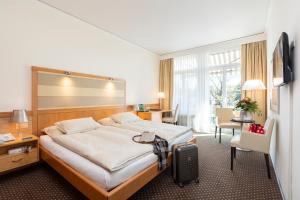 Una cama o camas en una habitación de Park-Hotel am Rhein - Gesundheitshotel und Residenzen