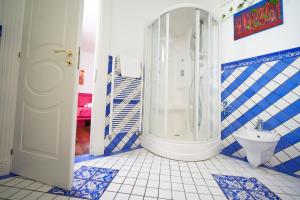 uma casa de banho azul e branca com um chuveiro e um WC em B&B Milleduecento Luxury Room em Salerno