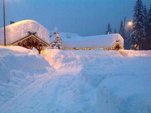 une pile de neige devant une maison dans l'établissement Chalet Al Lago, à San Vito di Cadore