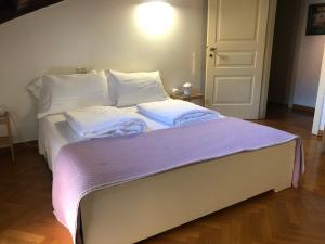 a bed with white pillows and a purple blanket at Residenza Privata Pedrotti in Vicenza