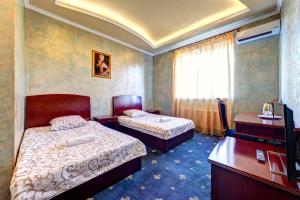 um quarto de hotel com duas camas e uma secretária em Hotel Kiev Lomakin em Kiev