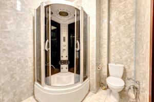 uma casa de banho com um WC e uma cabina de duche em vidro. em Hotel Kiev Lomakin em Kiev