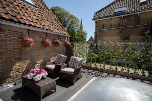 um pátio com duas cadeiras e flores numa cerca em !!!UNIEK!!! Rijksmonument centrum Harlingen em Harlingen