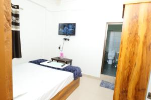 Habitación con cama y baño con espejo. en Hillside Hideaway Gudalur, en Gūdalūr