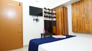 1 dormitorio con 1 cama con manta azul y puerta en Hillside Hideaway Gudalur, en Gūdalūr