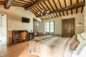 ein Schlafzimmer mit einem großen Bett und einem Schreibtisch in der Unterkunft Agriturismo Merigge Wellness & Spa Montepulciano in Montepulciano