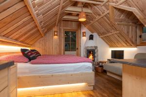 a bedroom with a bed in a room with a fireplace at ALPIK Chalets - Bohinj in Bohinj