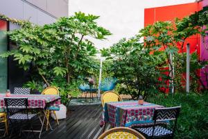 un patio con mesas, sillas y árboles en Aparthotel Adagio Access Paris Reuilly, en París